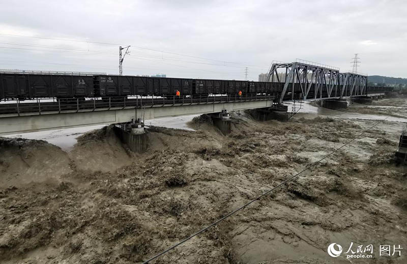 Un train de marchandises roule sur un pont pour éviter son effondrement lors des inondations 
