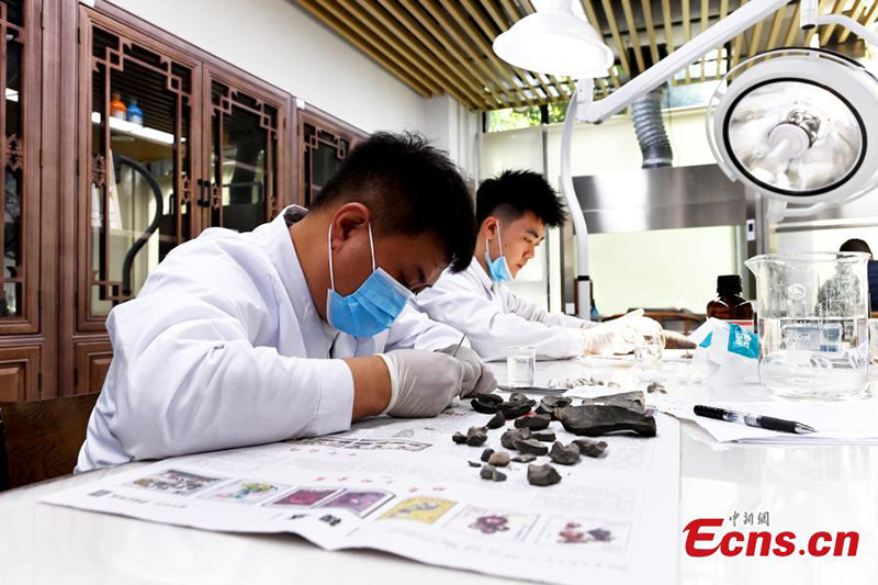Les gens font l'expérience de l'artisanat de restauration de reliques culturelles au Musée du Sichuan