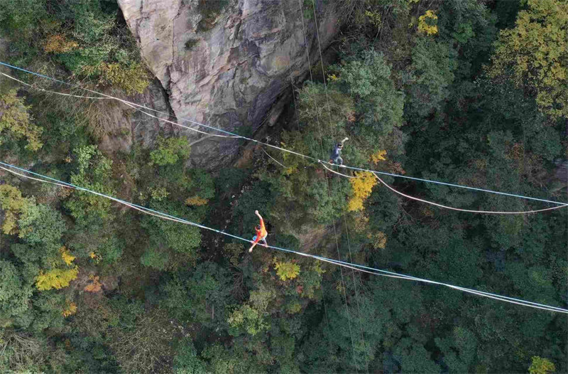 Les concurrents de slackline s'affrontent à 1 000 m d'altitude, au sommet des pics des forêts du site de Wulingyuan, dans le Hunan