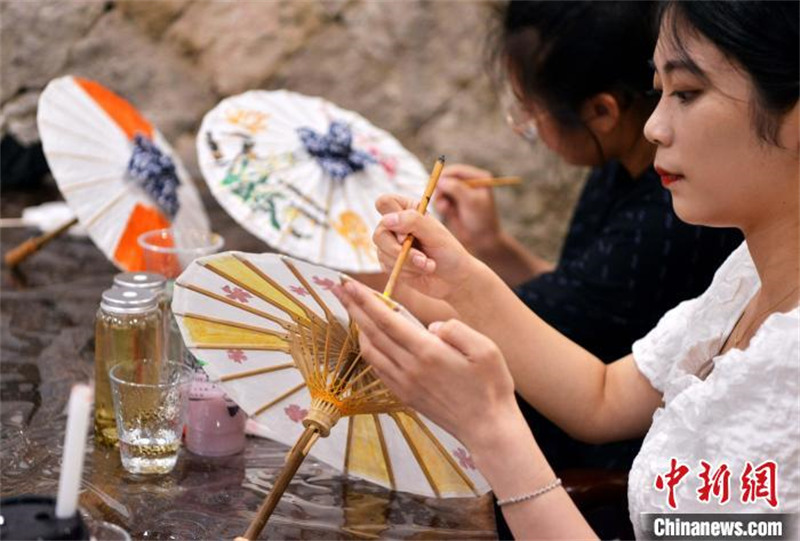 Fujian : des étudiants des deux côtés du détroit de Taiwan apprennent à fabriquer des parapluies en papier huilé à Fuzhou