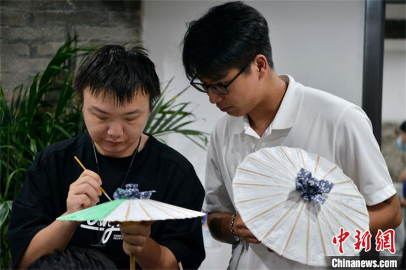Fujian : des étudiants des deux côtés du détroit de Taiwan apprennent à fabriquer des parapluies en papier huilé à Fuzhou