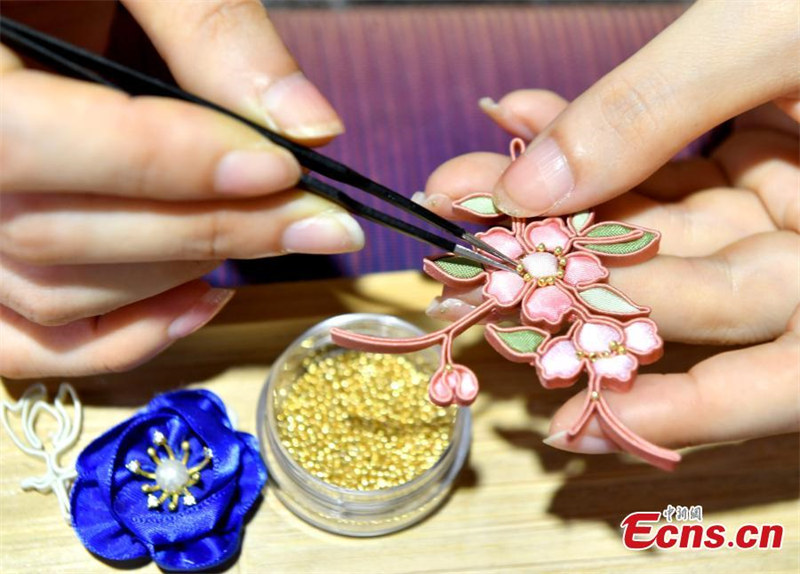 Une jeune femme se consacre aux boutons à nœuds traditionnels chinois