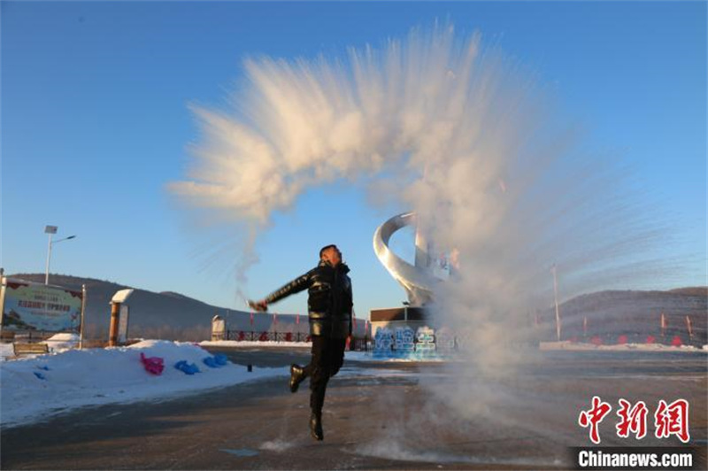 Des touristes jettent de l'eau dans l'air et l'eau se transforme immédiatement en un cercle de brouillard glacé dans le district de Huzhong, à Dahinggan, dans la province du Heilongjiang (nord-est de la Chine), le 5 janvier 2023. (Zhang Zhao / China News Service)