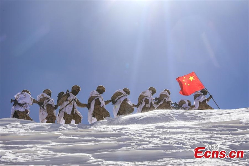 Photo prise le 21 mars 2023 montrant des soldats chinois marchant main dans la main sur une montagne enneigée pour patrouiller la zone frontalière à plus de 5 200 mètres d'altitude dans la préfecture d'Ali, dans la région autonome du Tibet (sud-ouest de la Chine). (Liu Xiaodong / China News Service)