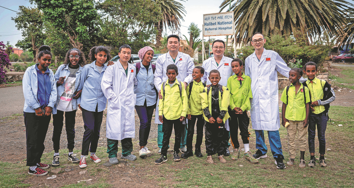 Des membres de l'équipe médicale chinoise posent pour une photo de groupe avec des étudiants locaux à la porte de l'hôpital Halibet, le 9 mai. (Wang Guansen / Xinhua)
