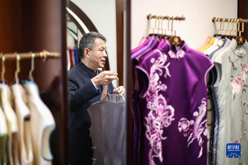 Jiang Manzong choisit un qipao pour une cliente dans la boutique de qipao « Dragon et Phénix », le 30 mai à Shanghai (est de la Chine). (Xin Mengchen / Xinhua)