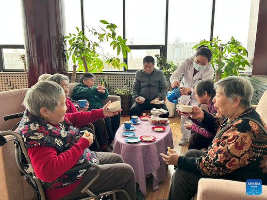 Des personnes âgées souffrant de troubles cognitifs prennent un café au centre de remédiation cognitive Hetong situé à Tianjin dans le nord de la Chine. (Photo/Xinhua)