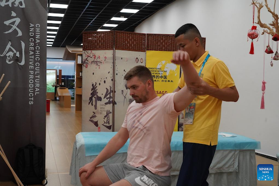 Un athlète fait l'expérience d'un massage de médecine traditionnelle chinoise (MTC) au village des Jeux de la FISU à Chengdu, capitale de la province du Sichuan (sud-ouest de la Chine), le 2 août 2023. (Tang Wenhao / Xinhua)