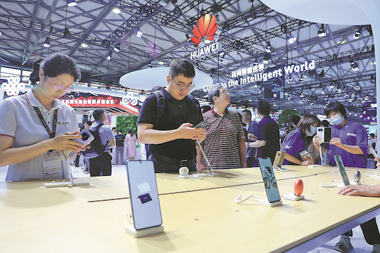 Des visiteurs essaient des téléphones portables Huawei lors d'une exposition à Shanghai. (Photo / China Daily) 