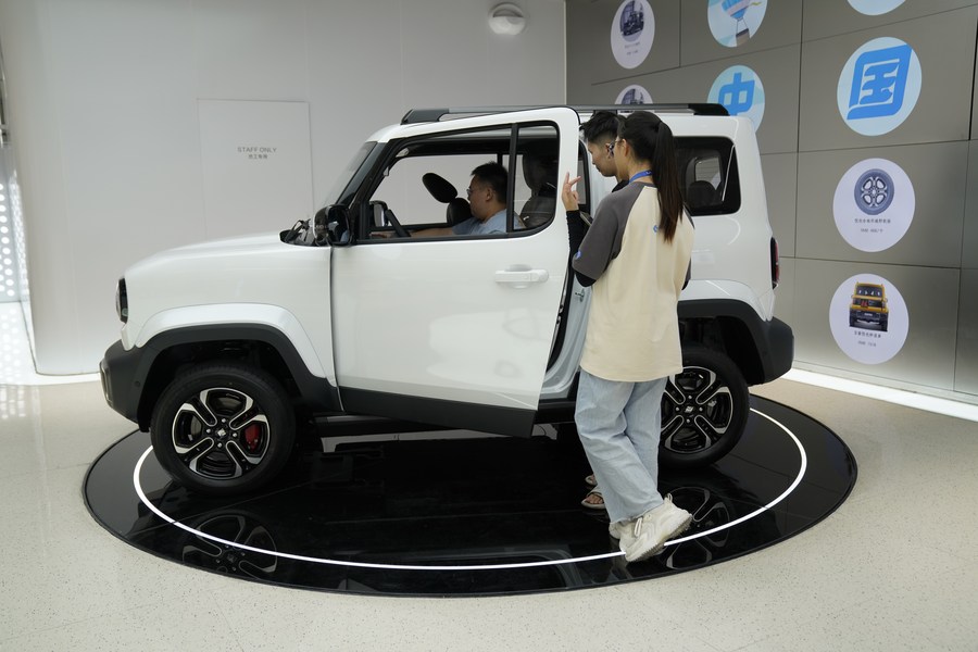 Des visiteurs se renseignent sur un véhicule à énergie nouvelle dans un magasin à Liuzhou, ville de la région autonome Zhuang du Guangxi (sud), le 5 juillet 2023. (Photo : Guo Yifan)