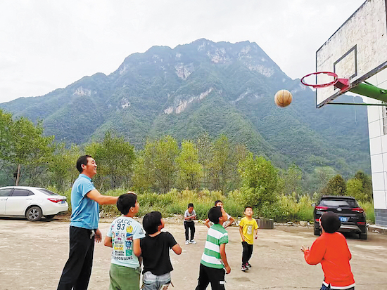 Zhu Xiangbing joue au basket-ball avec ses élèves. (Photo / China Daily)