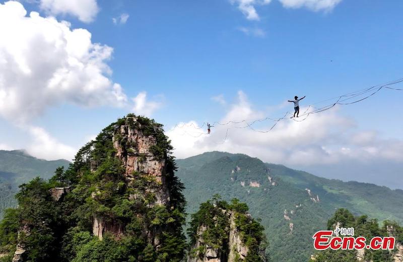 Des funambules marchent sur des cordes raides dans les airs lors d'un concours de slackline dans le Parc forestier national de Zhangjiajie, dans la province du Hunan (centre de la Chine), le 22 août 2023. (Wu Yongbing / China News Service)