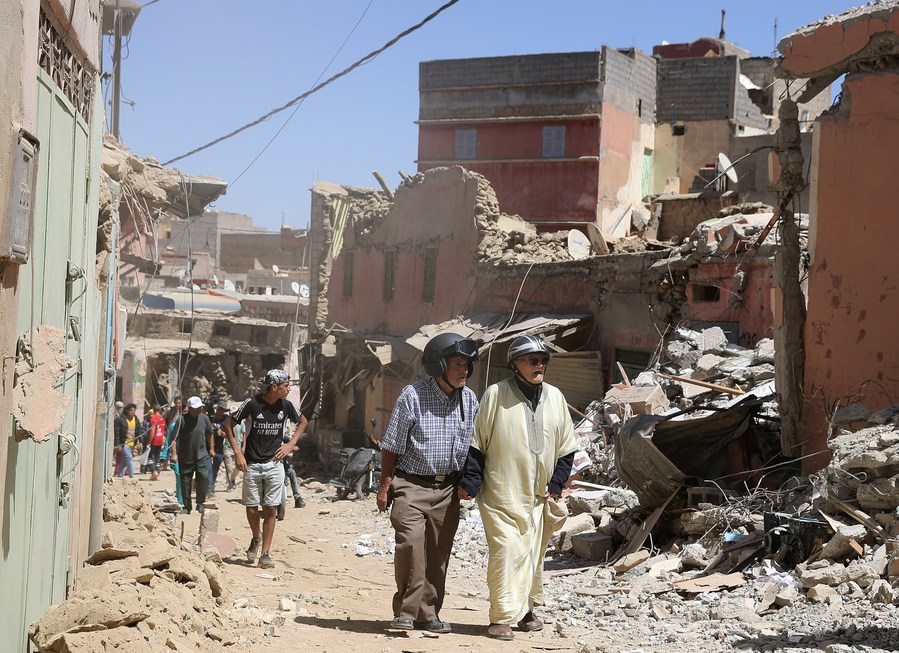 Des habitants passent devant des bâtiments endommagés le 10 septembre 2023 dans la petite ville d'Amizmiz, près de l'épicentre du séisme meurtrier qui a frappé le Maroc. (Xinhua/Wang Dongzhen)