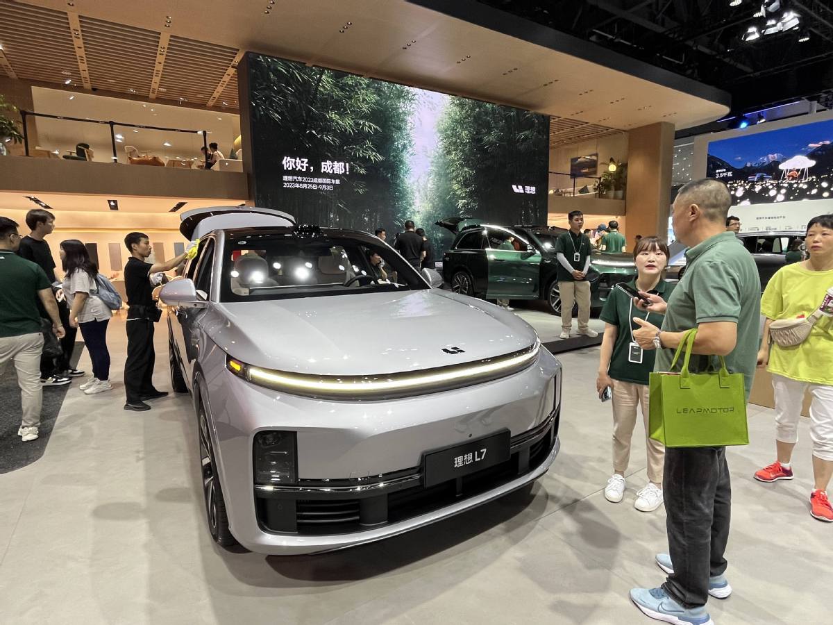 Une vendeuse présente le SUV L7 de Li Auto à un visiteur au Salon de Chengdu 2023 en août. (Cao Yingying / China Daily)