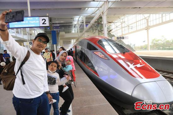 Une famille prend un selfie devant un train circulant sur la ligne ferroviaire à grande vitesse Jakarta-Bandung. (Li Zhiquan / China News Service)