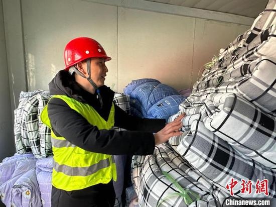 Un ouvrier apporte des couettes dans une maison temporaire nouvellement construite dans le comté de Jishishan, frappé par le tremblement de terre, dans la province du Gansu (nord-ouest de la Chine), le 21 décembre 2023. (Photo / China News Service)
