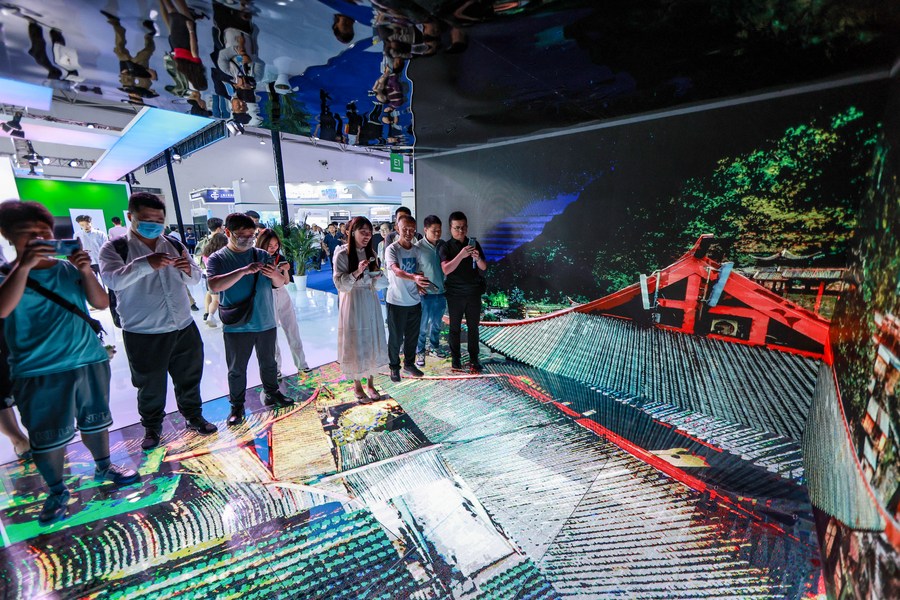 Des visiteurs regardent des vidéos faites par la technologie de l'informatique en nuage lors de l'Exposition internationale de l'industrie des données massives 2023, à Guiyang, dans la province chinoise du Guizhou (sud-ouest), le 26 mai 2023. (Photo : Ou Dongqu)