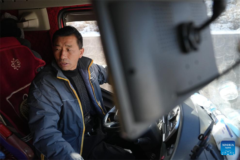 Ma Ming se rend en voiture à un point de transfert de maisons préfabriquées dans le canton de Liugou, à Jishishan, dans la province du Gansu (nord-ouest de la Chine), le 26 décembre 2023. (Chen Bin / Xinhua)