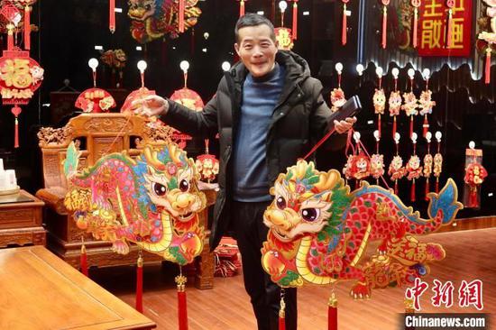 Wang Qiang montre des décorations sur le thème du dragon qu