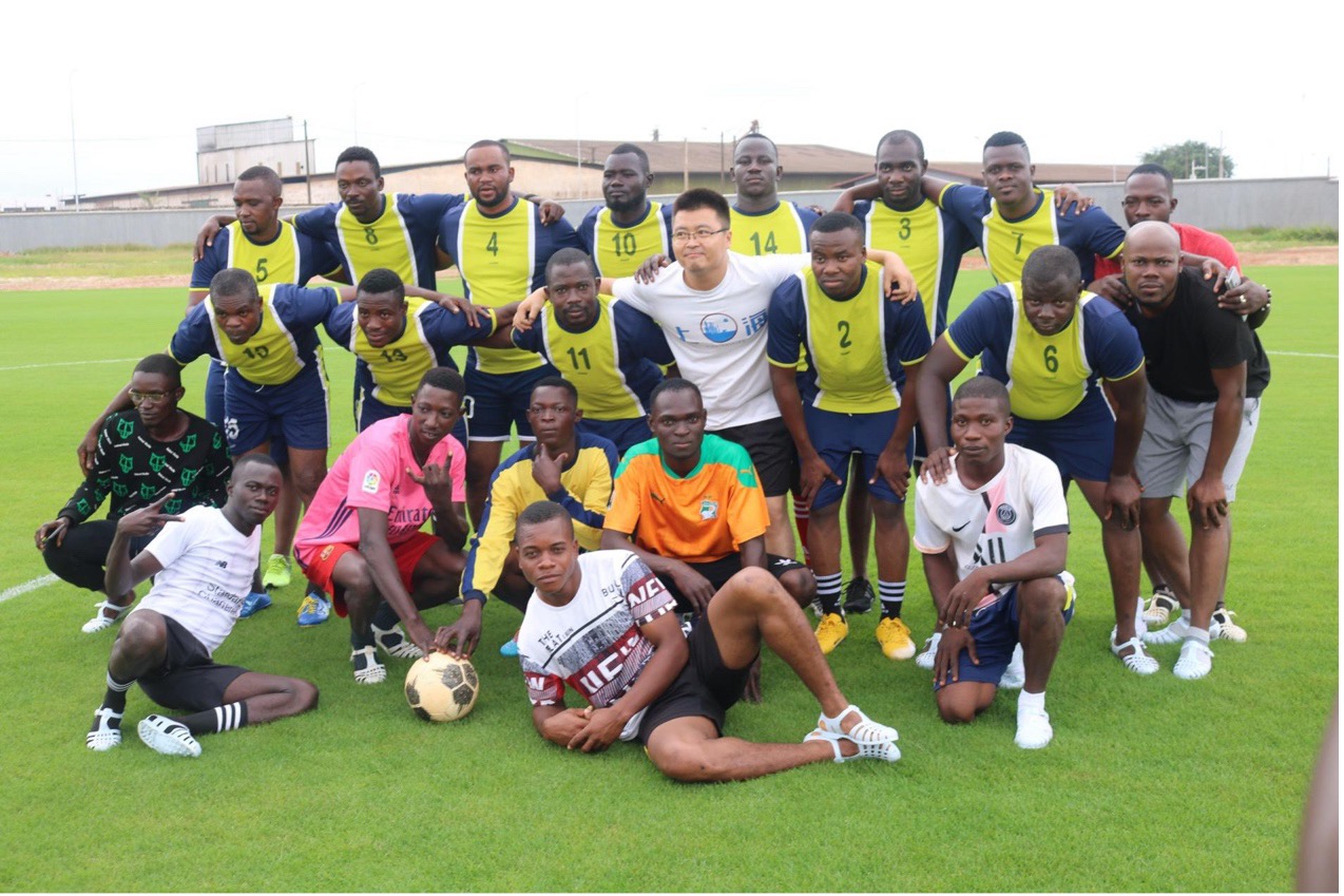 Des ingénieurs chinois et des locaux posent pour une photo devant le stade Laurent Pokou, à San-Pedro, en Côte d'Ivoire. (Photo / le Quotidien du Peuple en ligne)