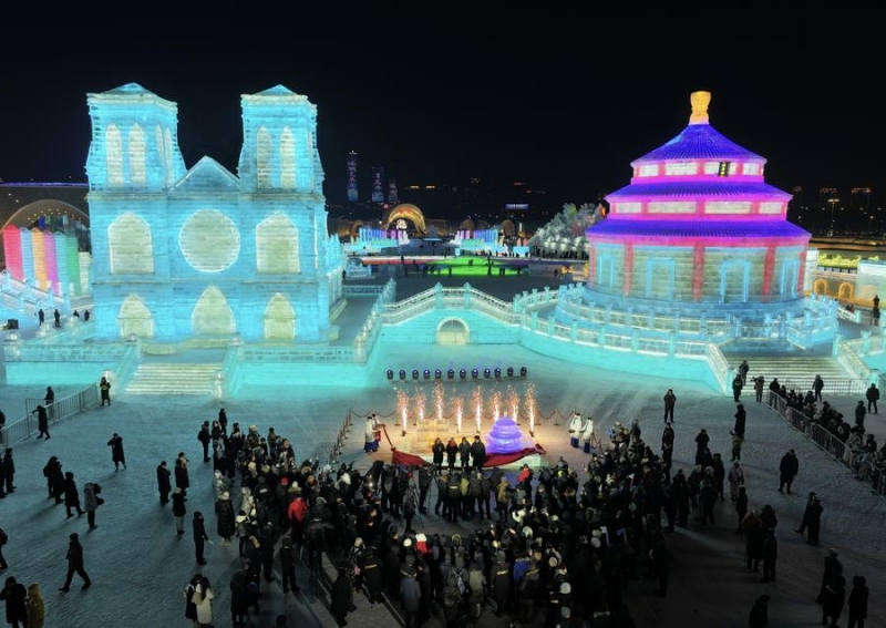 Des sculptures sur glace du Temple du Ciel de Beijing et de la Cathédrale Notre-Dame de Paris, éclairées par des lumières étincelantes, brillent sous le ciel nocturne de Harbin, capitale de la province du Heilongjiang, dans le nord-est de la Chine, le 6 janvier 2024. (Photo : Shi Feng)