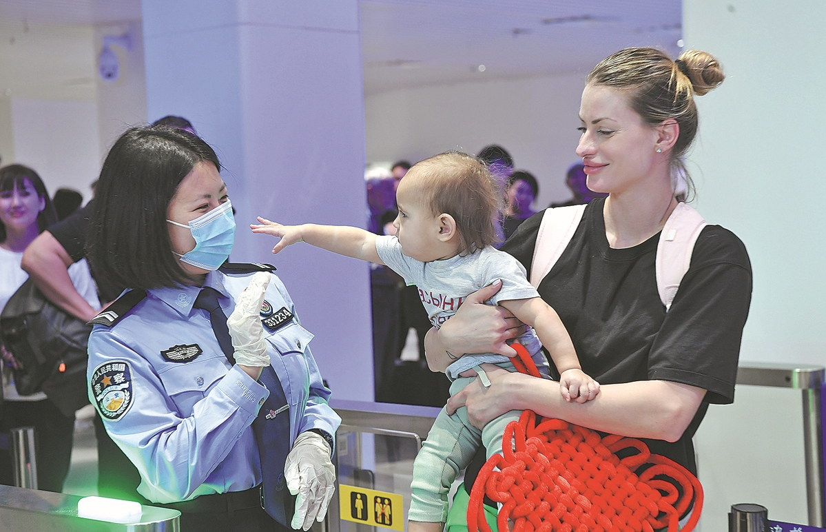 Un policier d'un poste d'inspection de l'immigration accueille les touristes arrivant à l'aéroport international de Phoenix de Sanya, dans la province de Hainan (sud de la Chine), le 31 janvier. (Zhao Yingquan / Xinhua)