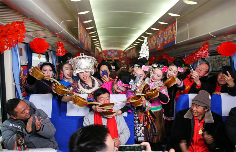 Le train vert se transforme en un lieu animé et festif, où des acteurs portant des vêtements traditionnels accueillent les passagers avec de l'alcool de riz. (Yang Wenbin/Xinhua)