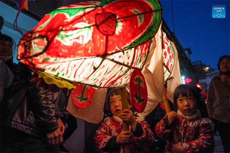 Photo prise le 31 janvier 2023 montrant des enfants tenant des lanternes en forme de poisson assistant à un défilé dans le comté de Shexian, à Huangshan, dans la province de l'Anhui (est de la Chine). (Du Yu / Xinhua)