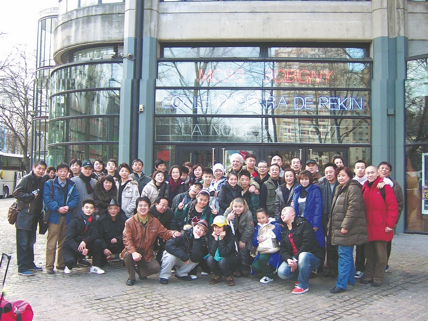 Patrick Sommier pose avec des membres d'une troupe invitée du Collège professionnel d'opéra et d'arts de Beijing devant un théâtre à Bobigny, près de Paris, en 2010. (Photo / Xinhua)