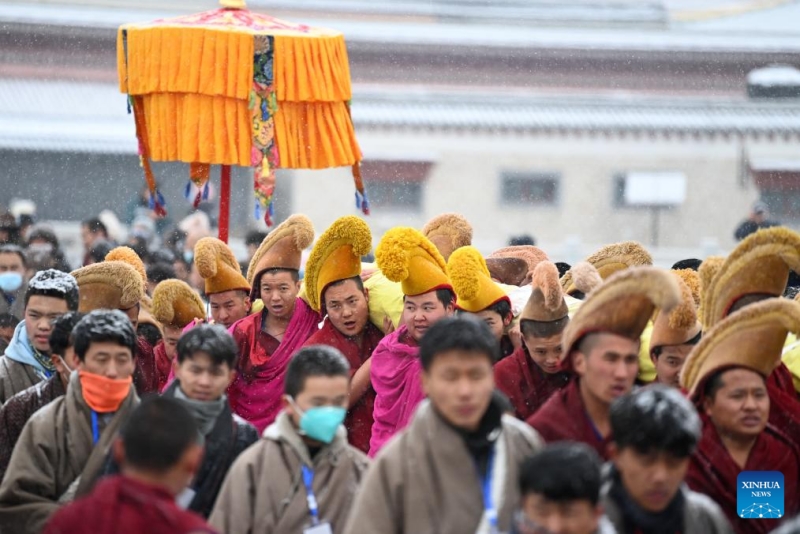 Des moines portent une immense peinture Thangka portant l'image du Bouddha lors de la cérémonie annuelle du "soleil du Bouddha" du monastère Labrang dans le comté de Xiahe, dans la province du Gansu (nord-ouest de la Chine), le 22 février 2024. (Fang Xin / Xinhua)