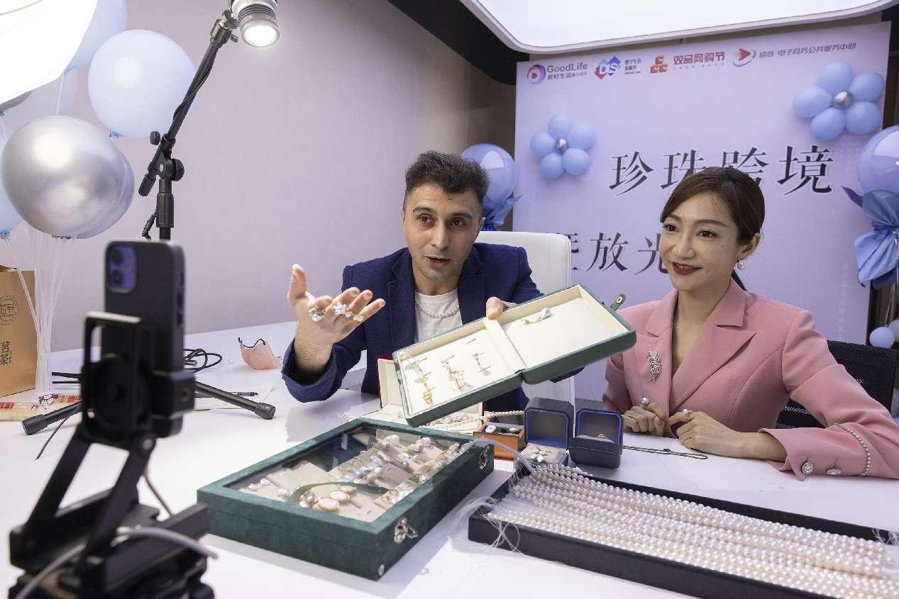 Deux animateurs vendent des bijoux via une diffusion en direct transfrontalière dans une bijouterie à Zhuji, dans la province du Zhejiang (est de la Chine). (Guo Bin / Pic.people.com.cn)