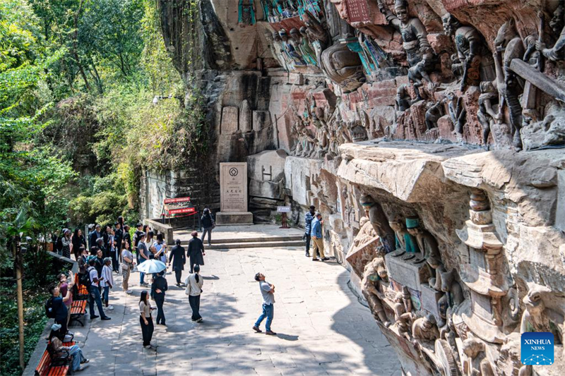 Des touristes visitent le site touristique des sculptures rupestres de Dazu à Chongqing