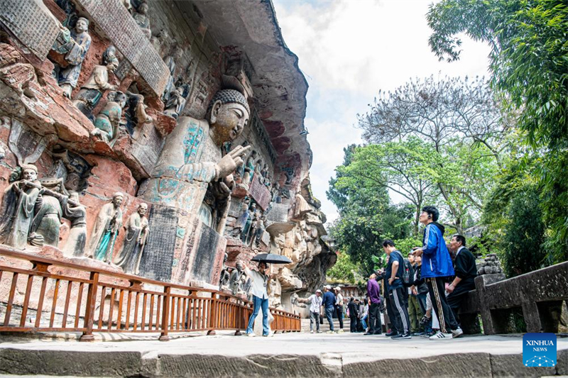 Des touristes visitent le site touristique des sculptures rupestres de Dazu à Chongqing