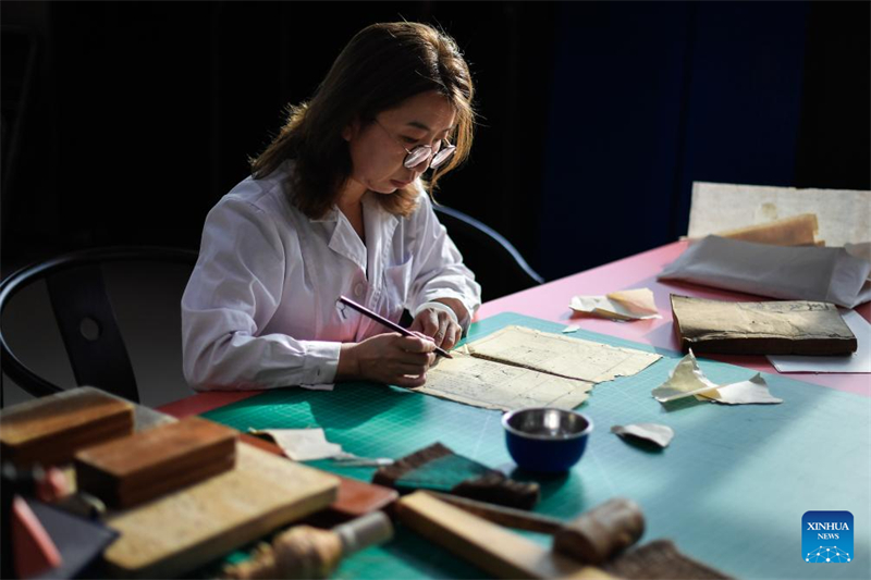 Zhang Hua, restauratrice de livres anciens à la bibliothèque de l'Université du Jilin, travaille à la restauration d'un livre ancien à la bibliothèque de l'Université du Jilin à Changchun, capitale de la province du Jilin (nord-est de la Chine), le 19 avril 2024. (Xu Chang / Xinhua)