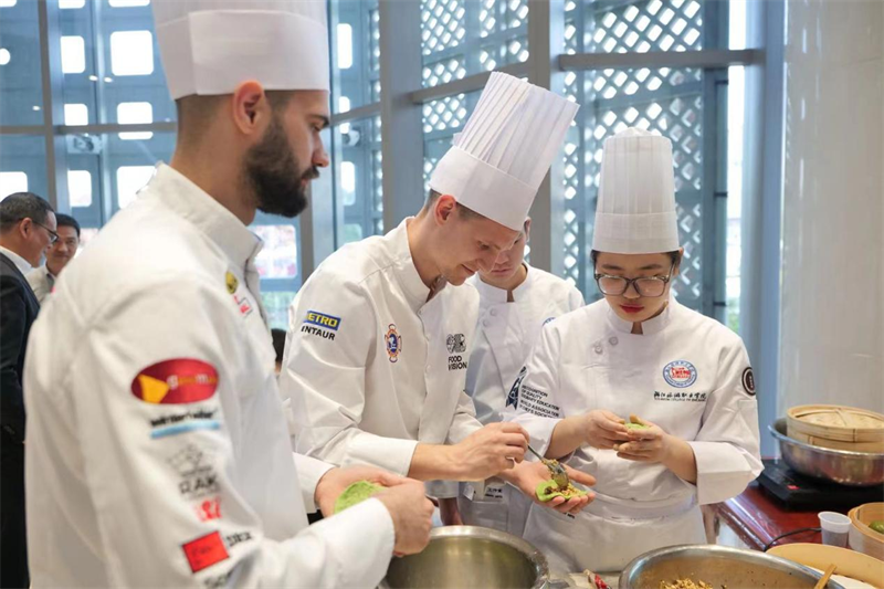Le 11 avril, l'événement « Merveilleux goût chinois - Banquet du Lac de l'Ouest » a eu lieu au Centre culturel chinois de Belgrade, capitale de la Serbie. Les plats de l'événement ont tous été préparés par des professeurs chinois et des étudiants de l’Ecole professionnelle de tourisme du Zhejiang et des étudiants serbes de l'atelier Luban. La photo montre des enseignants et des étudiants chinois et serbes confectionnant des Qingtuan, des boulettes de riz vert farcies sucrées. (Photo fournie par le Centre culturel chinois de Belgrade)