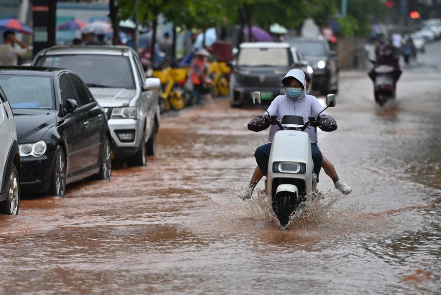 Des habitants en scooter électrique dans une rue inondée de Nanning, dans la région autonome Zhuang du Guangxi (sud de la Chine), le 8 mai 2024. (Photo : Zhou Hua)