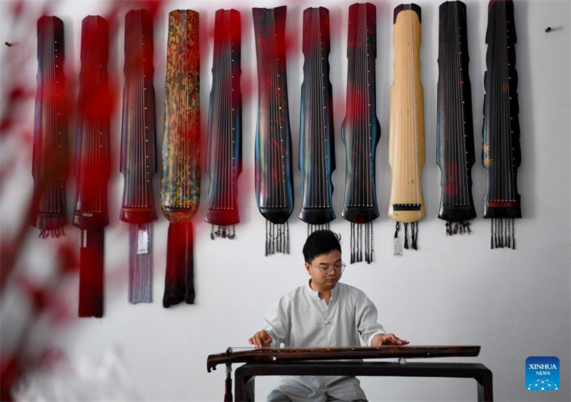 Xu Bing, un fabricant d'instruments, joue du guqin, un instrument de musique traditionnel chinois à sept cordes pincées, chez lui dans le comté de Lankao de la ville de Kaifeng, dans la province du Henan (centre de la Chine), le 13 mai 2024. (Hao Yuan / Xinhua)