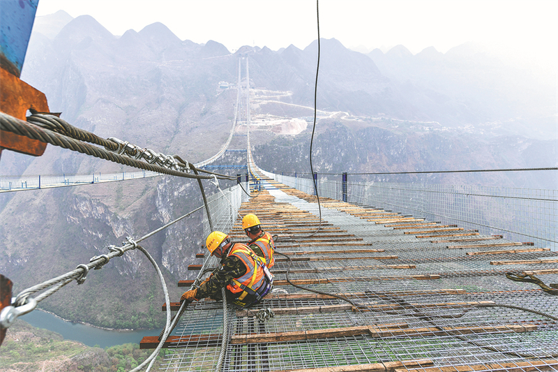 Des constructeurs travaillent sur le chantier de construction du pont du Grand canyon de Huajiang, le 27 mars. (Yang Wenbin / Xinhua)
