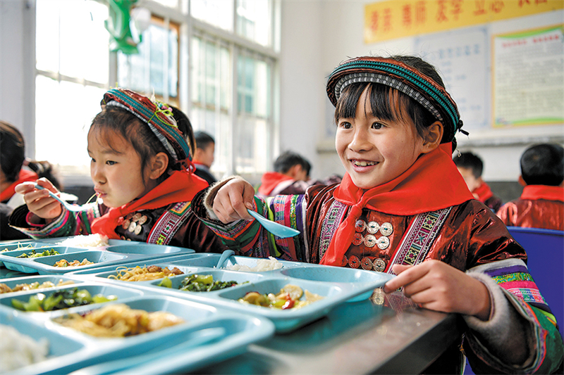 Des élèves profitent d'un déjeuner gratuit et nutritif le 16 février 2023 à Xishan, dans le comté de Congjiang de la province du Guizhou (sud-ouest de la Chine). (Yang Wenbin / Xinhua)