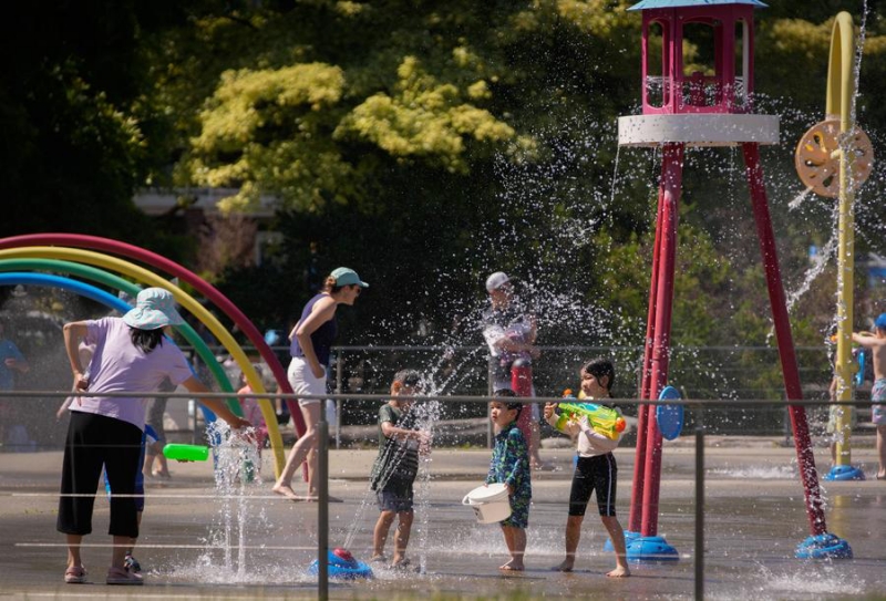 Des enfants se rafraîchissent dans un parc à jets d