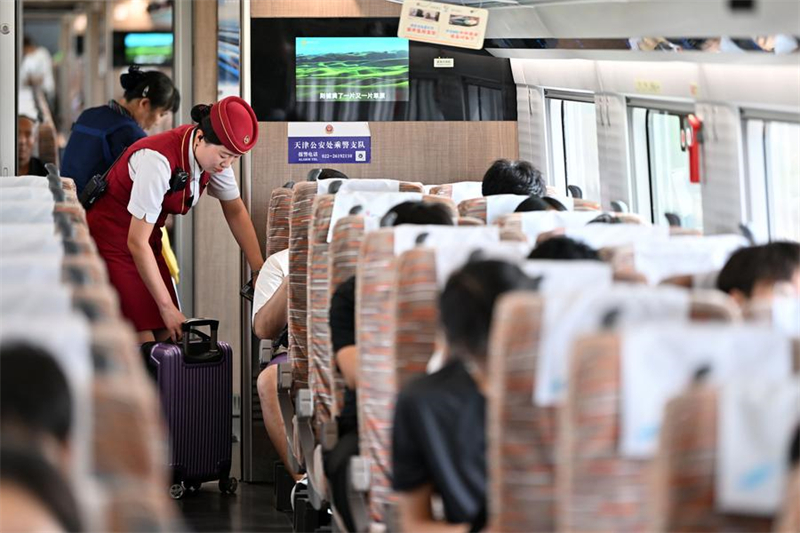 Une employée de la compagnie de chemin de fer en plein service à bord du train à grande vitesse G8844 reliant la municipalité de Tianjin, dans le nord de la Chine, à l'aéroport international Daxing de Beijing, le 6 juillet 2024. (Photo : Li Ran)