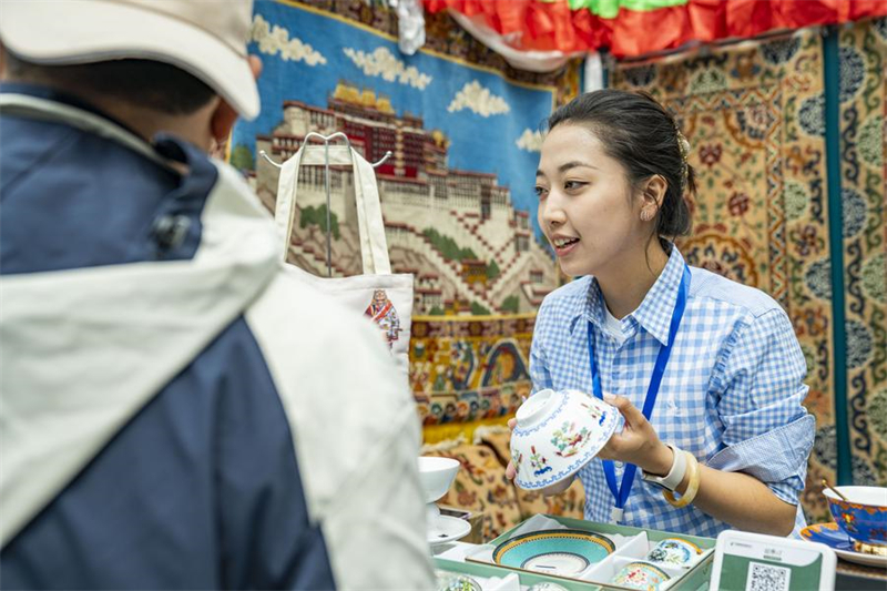 Une vendeuse explique les caractéristiques d'un produit à un visiteur lors de la 5e Exposition du tourisme et de la culture du Xizang (Chine) à Lhassa, capitale de la région autonome du Xizang, dans le sud-ouest de la Chine, le 18 juin 2023. (Photo : Su Fei)