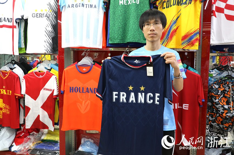 Photo montrant un maillot de supporter, de couleur majoritairement bleu, avec des éléments du drapeau national français sur les poignets et le col. (Fang Pengyimeng / Le Quotidien du Peuple en ligne)