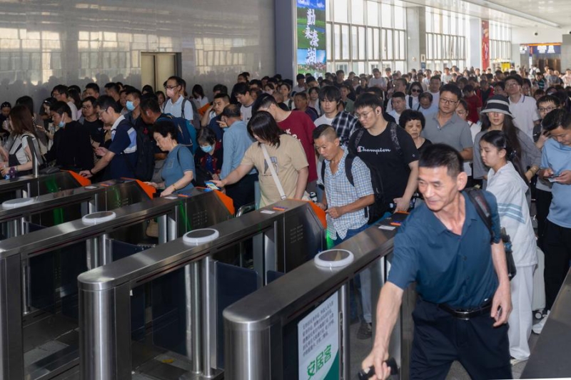 Des passagers font la queue pour le contrôle des billets à la Gare de Shanghai, dans l