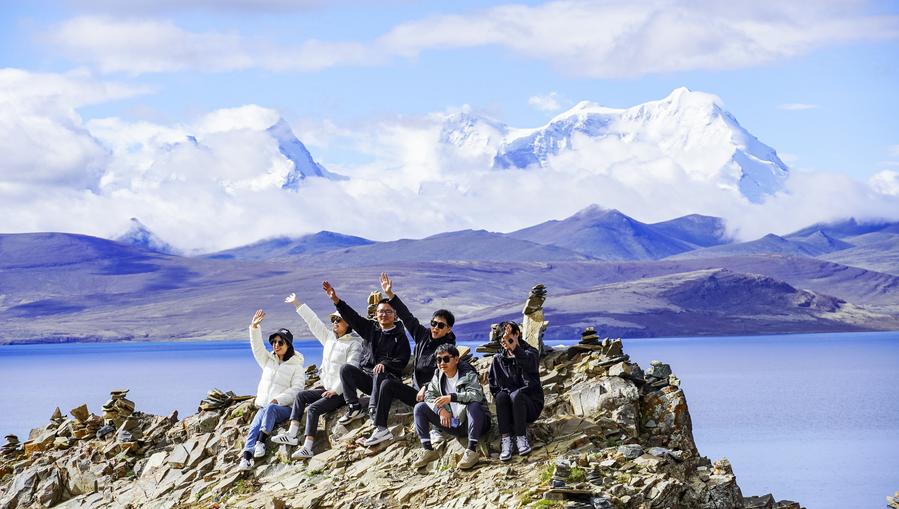 Des touristes posent pour des photos au bord du lac Puma Yumco, dans le district de Nagarze de Shannan, dans la région autonome du Xizang, dans le sud-ouest de la Chine, le 4 juillet 2023. (Photo : Chen Shangcai)