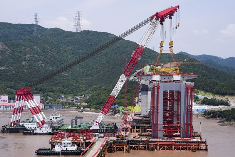 Photo montrant l'installation de la première poutre en acier du pont autoroutier et ferroviaire de Xihoumen, dans la province du Zhejiang (est de la Chine), 27 mai 2025. (Photo / Xinhua)