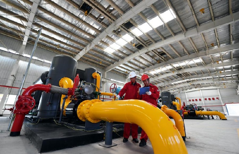 Cette photo, prise le 25 juin 2022, montre des ouvriers vérifiant des équipements dans l'atelier d'une base minière de méthane de houille dans le district de Qinshui, dans la province du Shanxi (nord de la Chine). (Wang Feihang / Xinhua)
