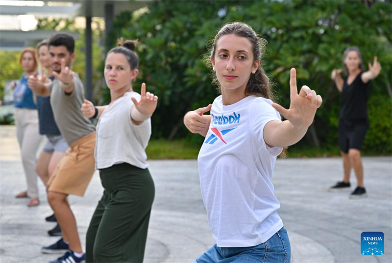 Des stagiaires étrangers apprennent le Baduanjin, un exercice traditionnel de respiration et d'étirement, à Sanya, dans la province de Hainan (sud de la Chine), le 7 août 2025. (Guo Cheng/Xinhua)