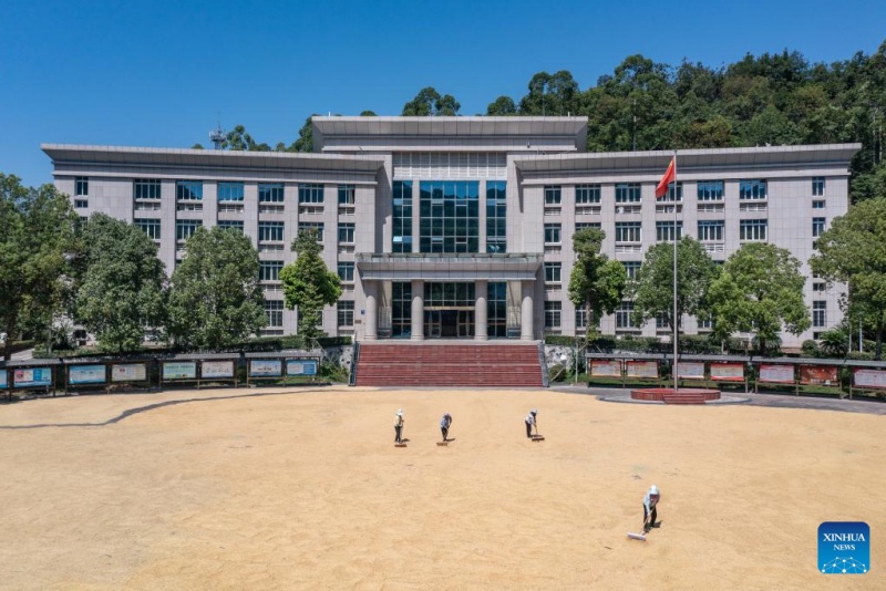 Chongqing : des agriculteurs font sécher des céréales dans une enceinte administrative du district de Yongchuan