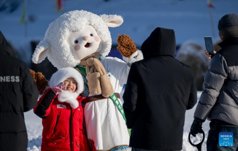 Un enfant pose pour des photos avec un personnage de dessin animé lors de la cérémonie d'ouverture de la 21e Foire de la glace et de la neige du Nadam de la région autonome de Mongolie intérieure, dans le district de Hailar, à Hulun Buir, dans la région autonome de Mongolie intérieure (nord de la Chine), le 21 décembre 2025. La foire du Nadam a débuté ici le 21 décembre, attirant des touristes chinois et étrangers. (Xinhua/Lian Zhen)
